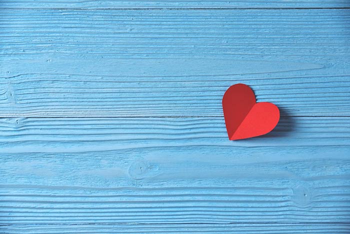 Valentines day. A Red heart on blue wooden background. Copy space.