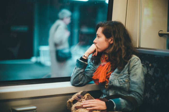 Woman inside a train looking out the window 