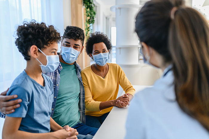 A masked family visiting their primary care physician