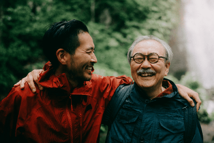 father and son on a hike stop to smile for the camera