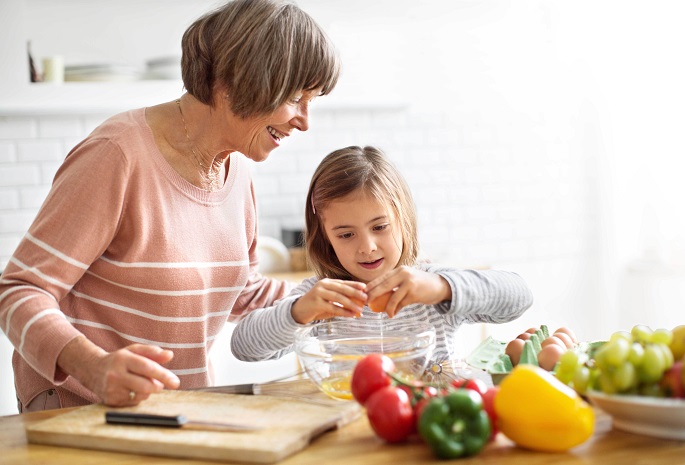 woman and young granddaughter preparing a healthy breakfast