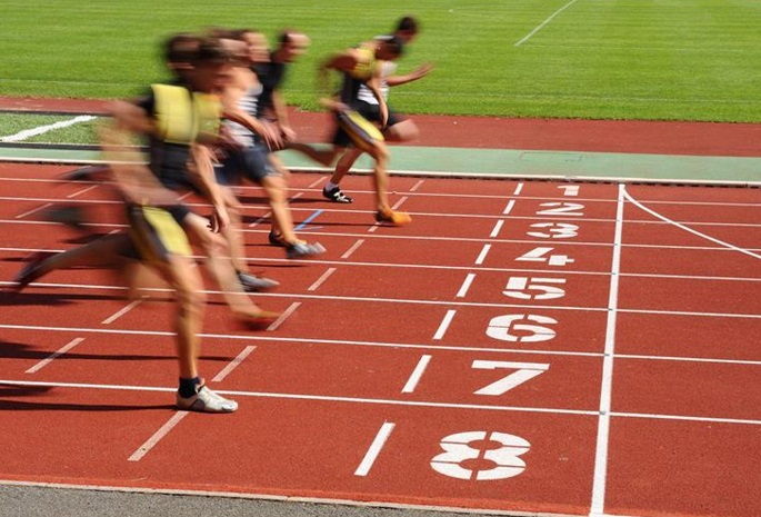 track runners racing about to cross finish line