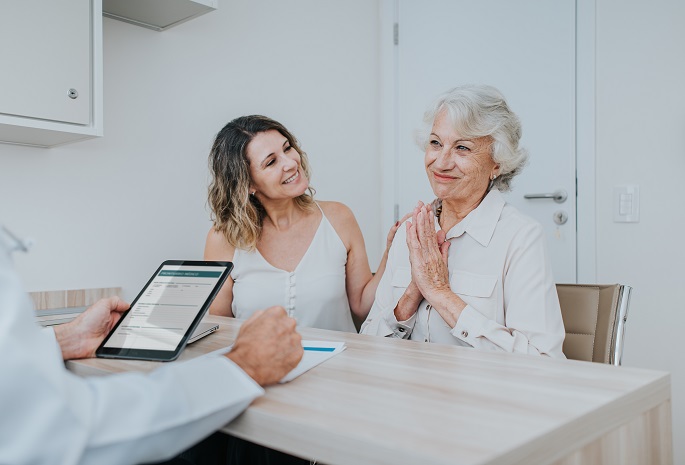 adult daughter and mother meet with doctor