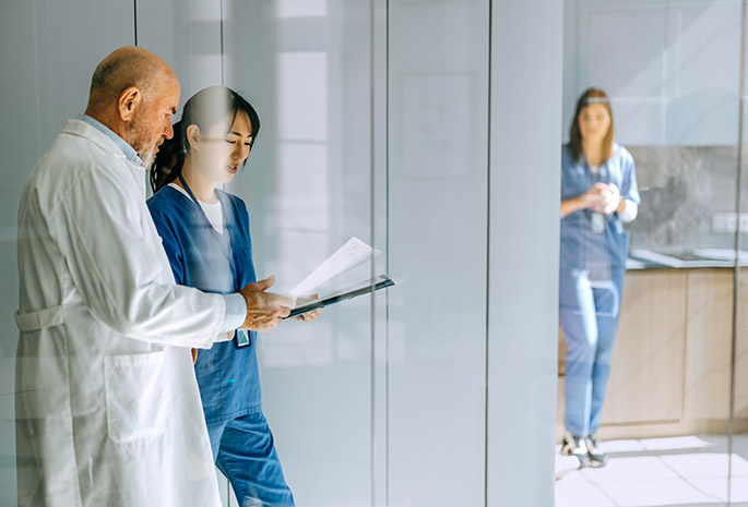 Doctor consults with APP as they walk down hallway