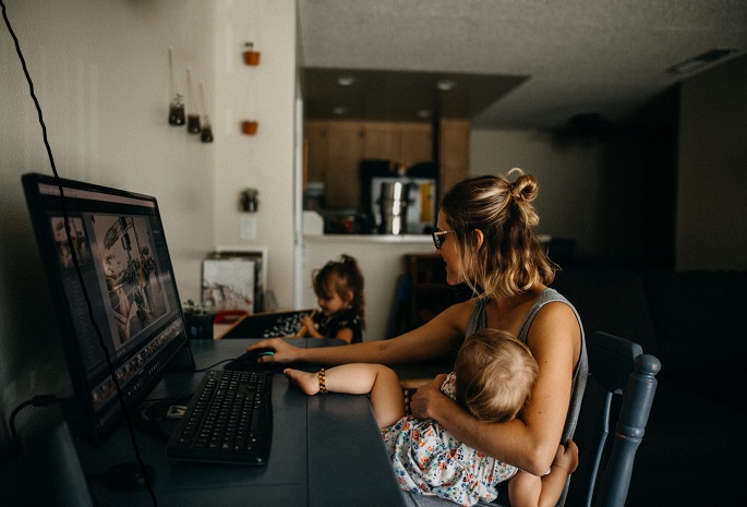 mother at home with children working remotely on laptop