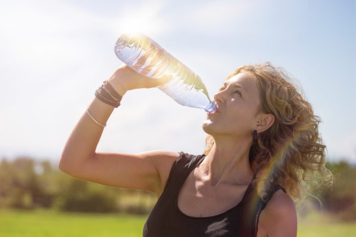 women drinking water in the sun