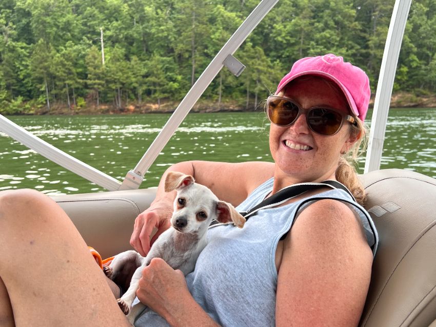 woman sitting in boat with dog
