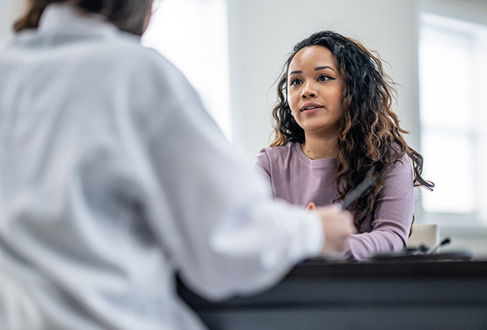 young woman at sitting across a doctor